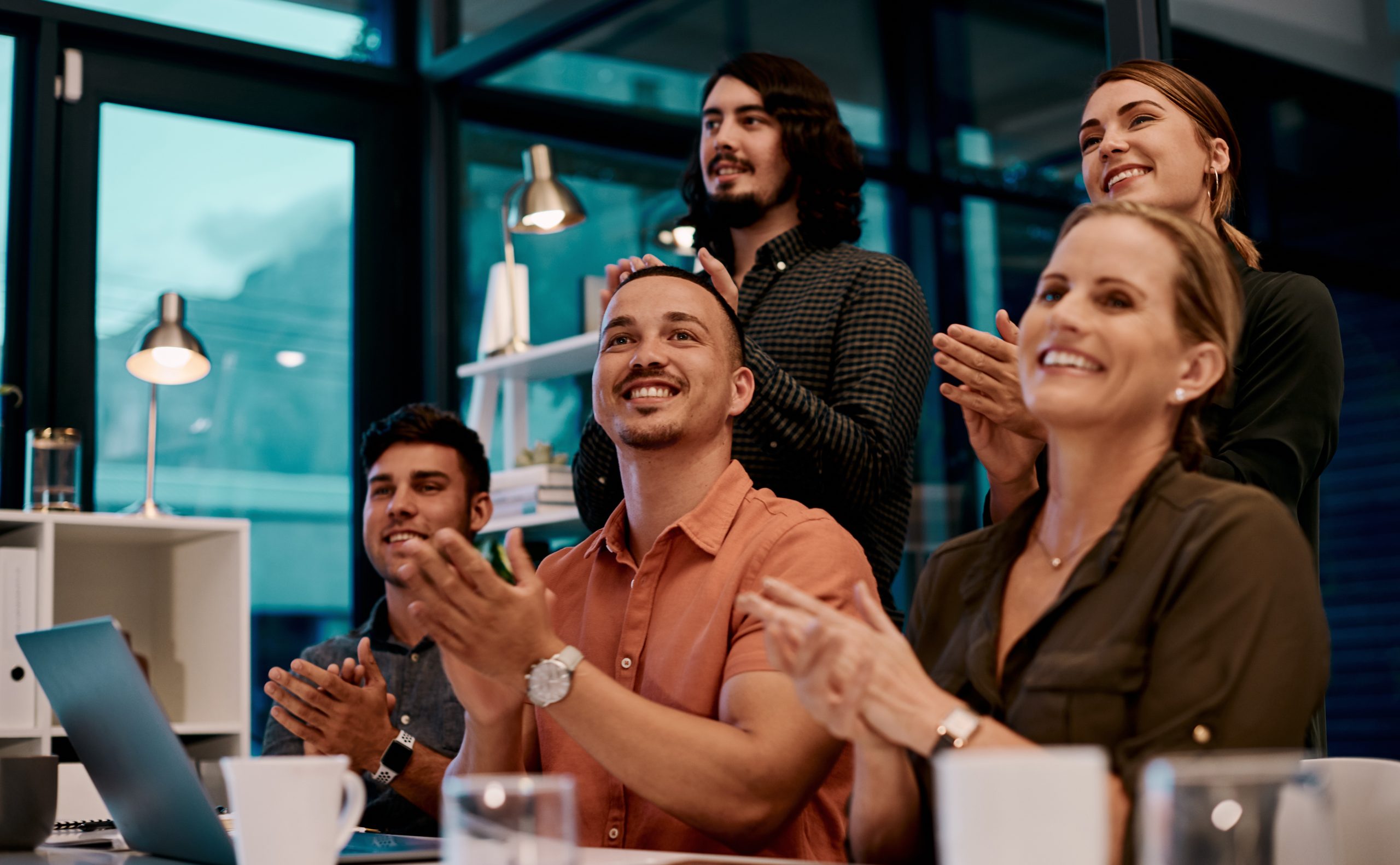 Shot of a group of businesspeople applauding while sitting in the boardroom.