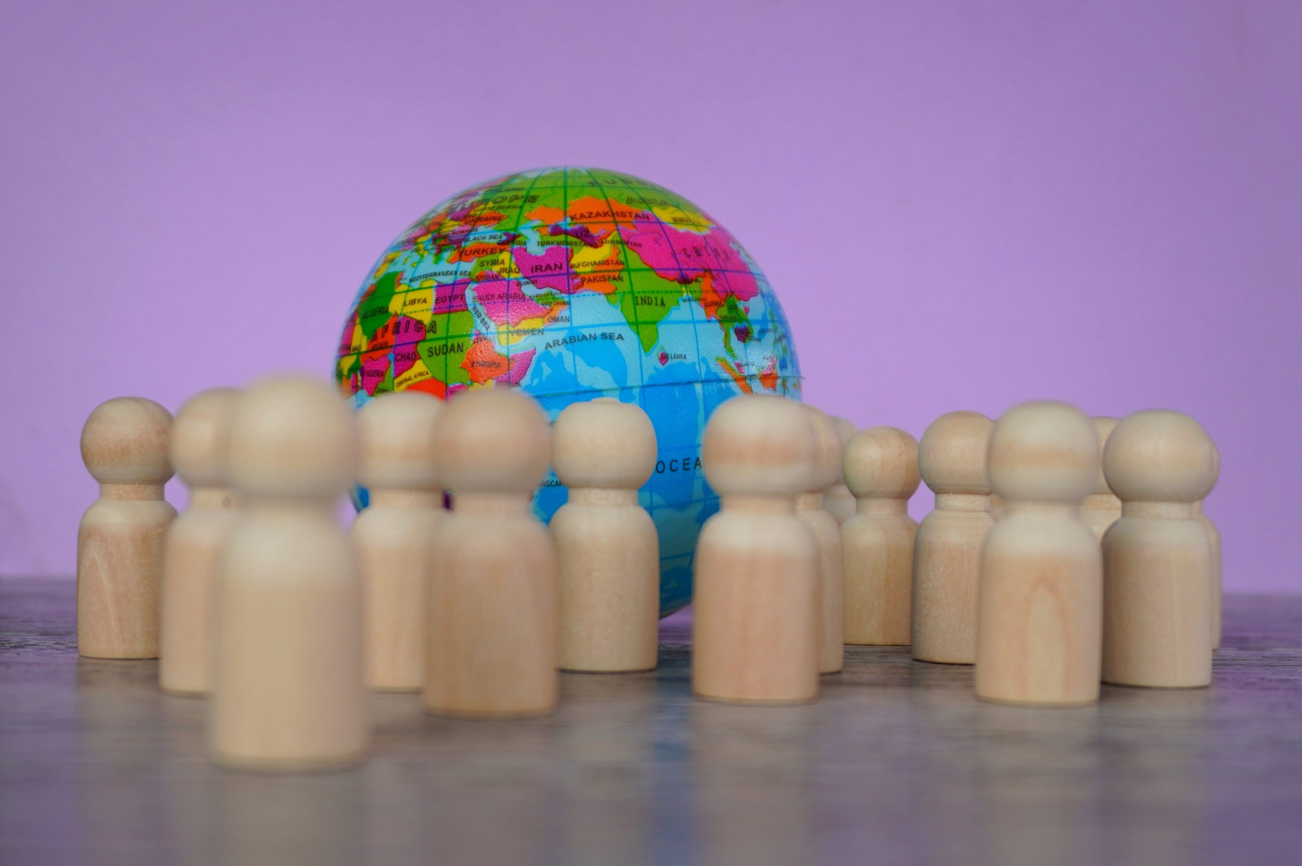 Wooden dolls and earth globe. World Population Day concept